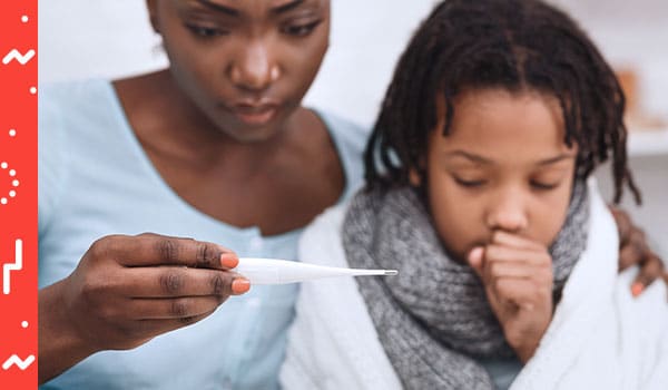 Mother reading thermometer with coughing child.