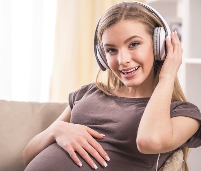 pregnant woman wearing headphones.